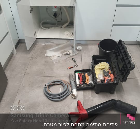 כלי עבודה של אינסטלטור, כולל צינורות וארגז כלים פתוח